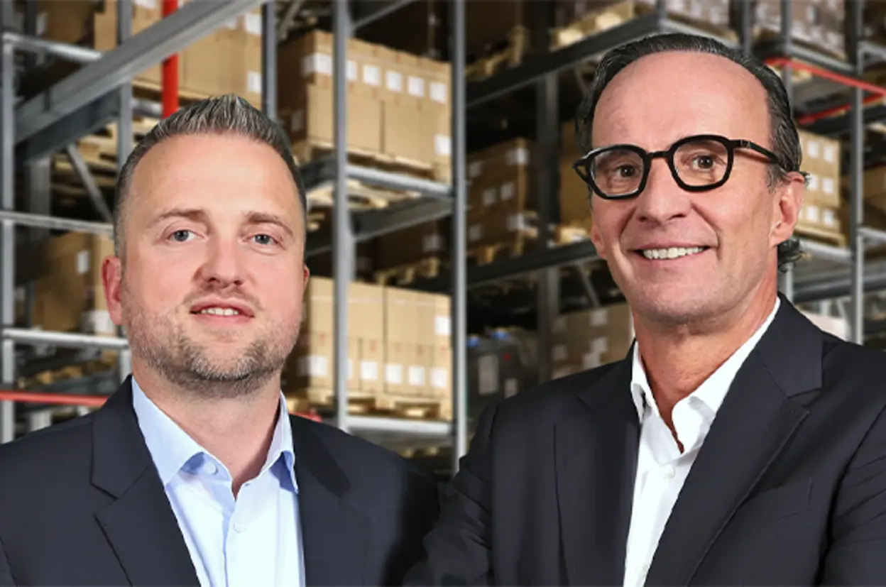 Geschäftsführer von Queisser Pharma in Anzügen vor einem Hochregallager