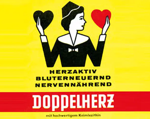 На изображении женщина с темными волосами, стоящая на желтом фоне. Она держит в руках два сердца: одно черное, другое красное. В нижней части написано слово “Doppelherz” и фразы на немецком языке, связанные с активностью сердца и питательностью.